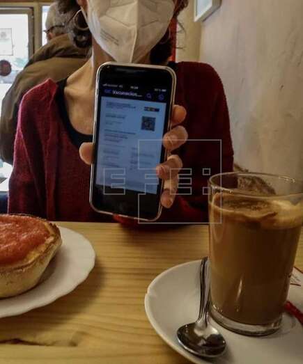 Una chica muestra en el móvil su certificado covid digital de la UE en una cafetería / EFE Jose Manuel Vidal